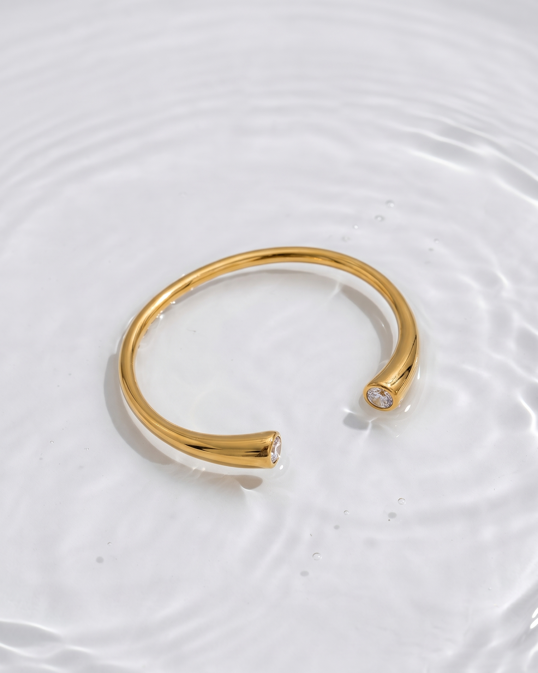 Gold bracelet with a diamond on a white background