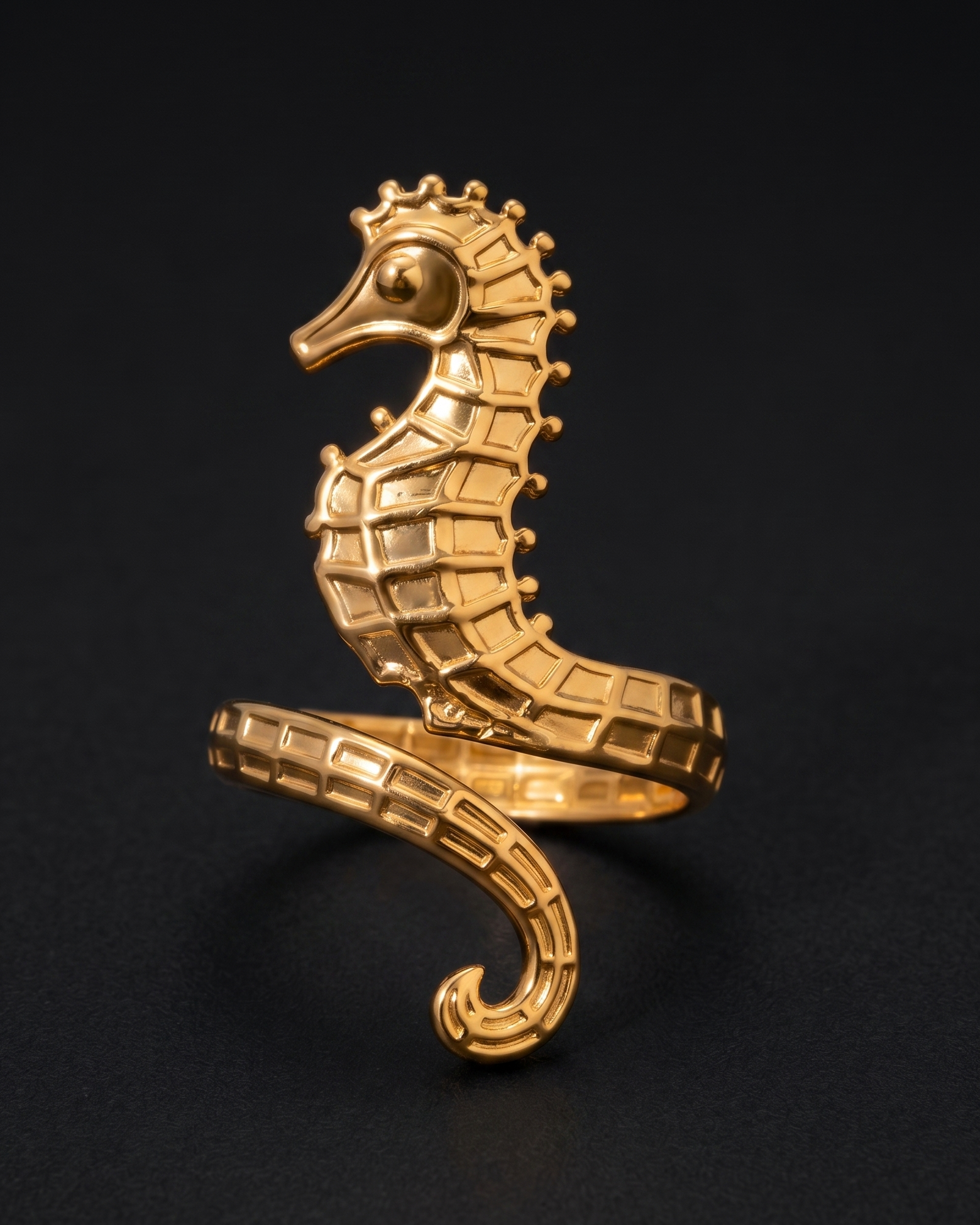 Gold seahorse-shaped ring on a black background