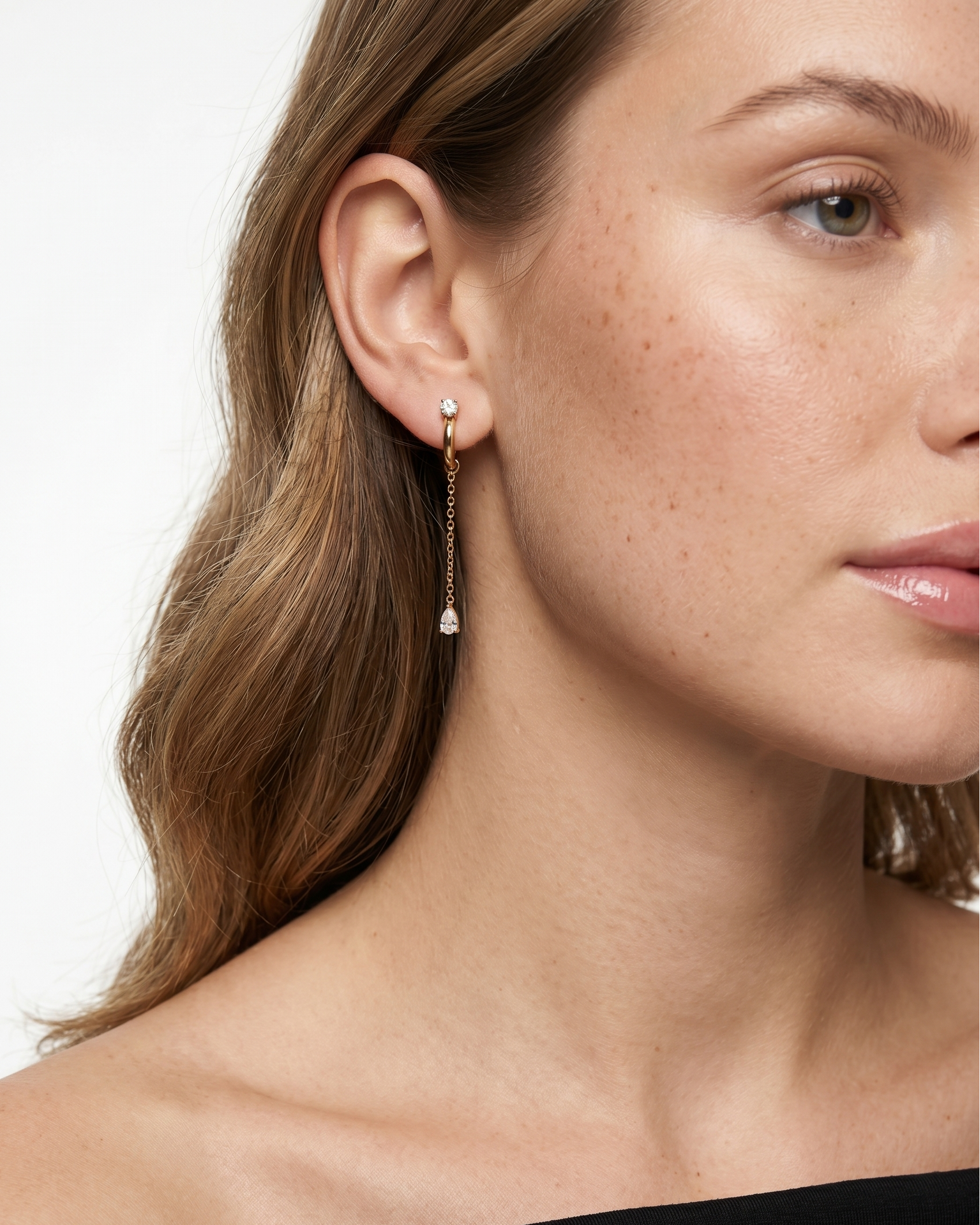 Close-up of a woman wearing a delicate earring with a white background