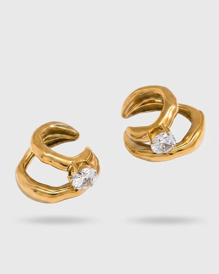 Gold hoop earrings with clear gemstones on a light gray background