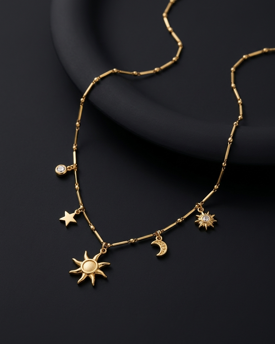 Gold necklace with celestial charms on a dark background