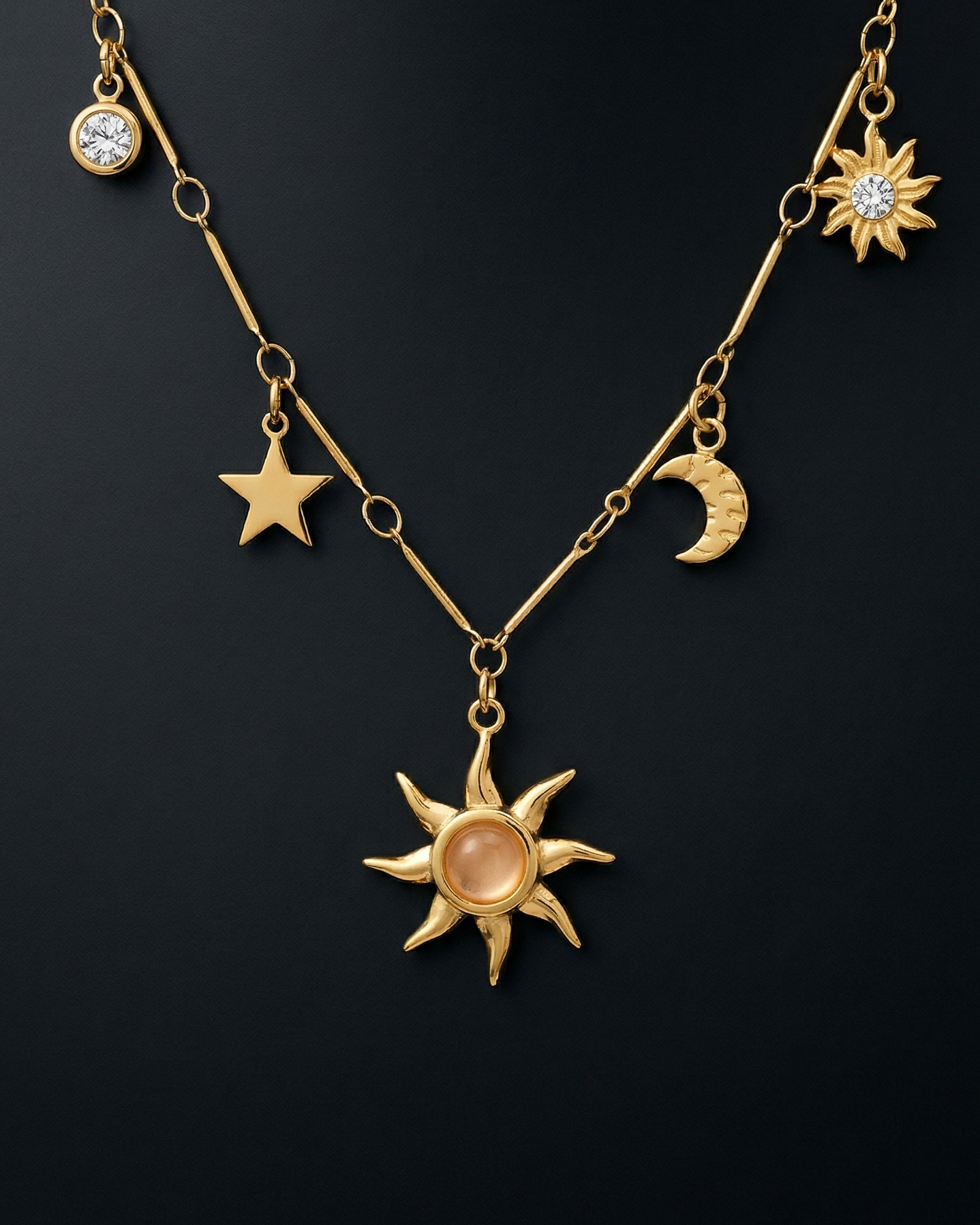 Gold necklace with celestial pendants on a black background