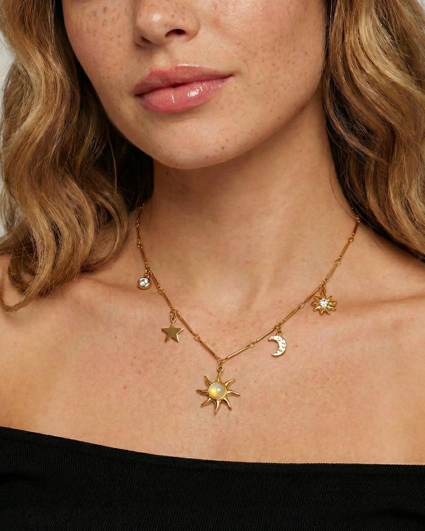 Necklace with celestial pendants worn by a person