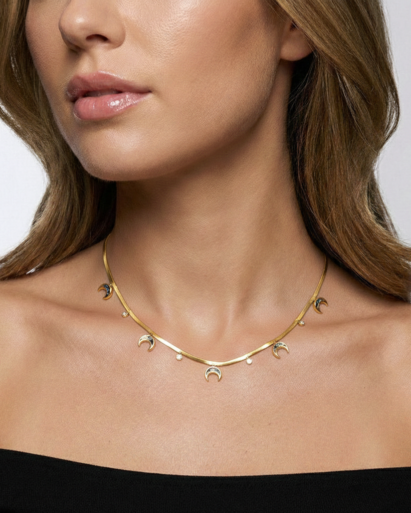 Gold necklace worn by a model on a plain background