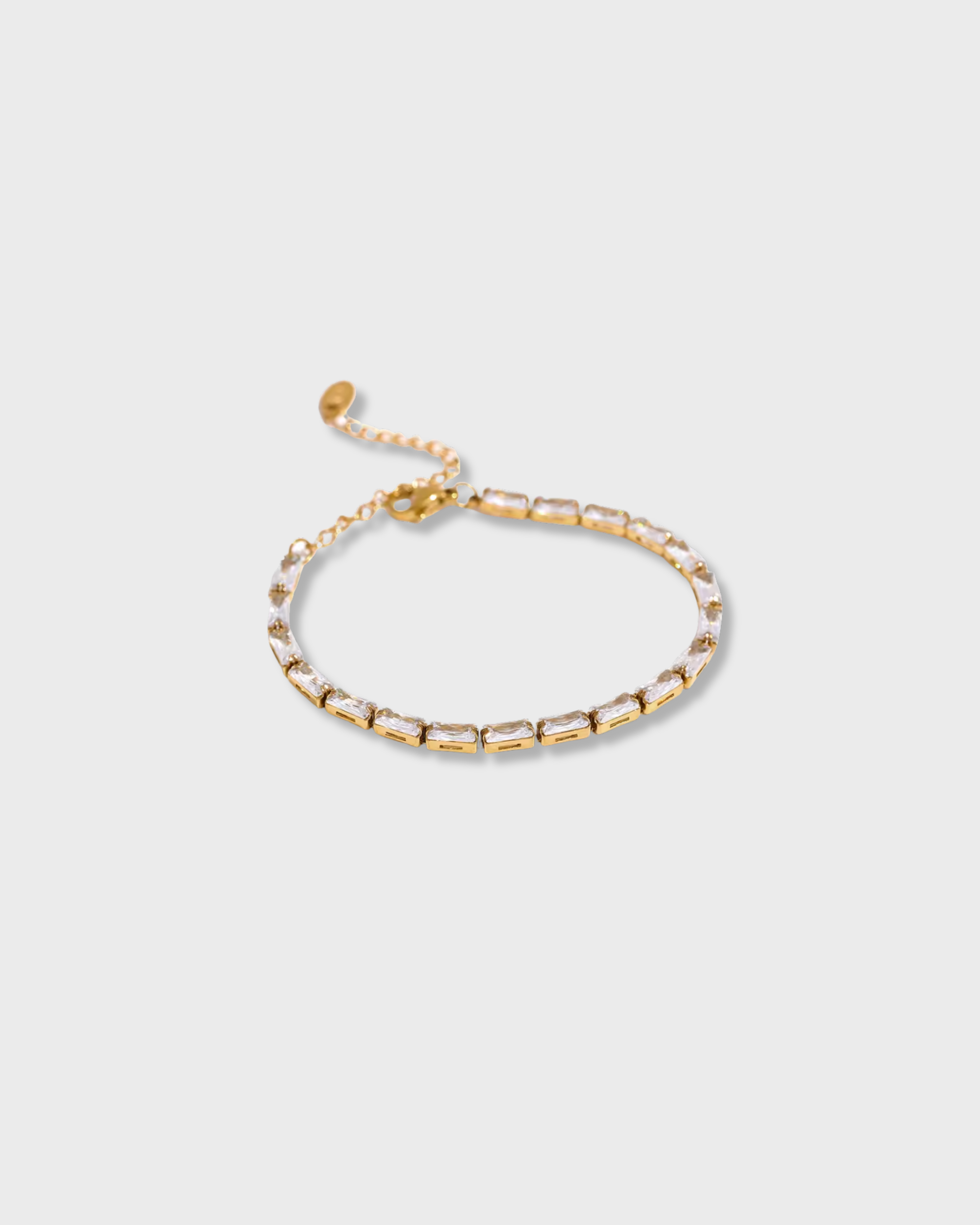 Gold chain bracelet on a light gray background