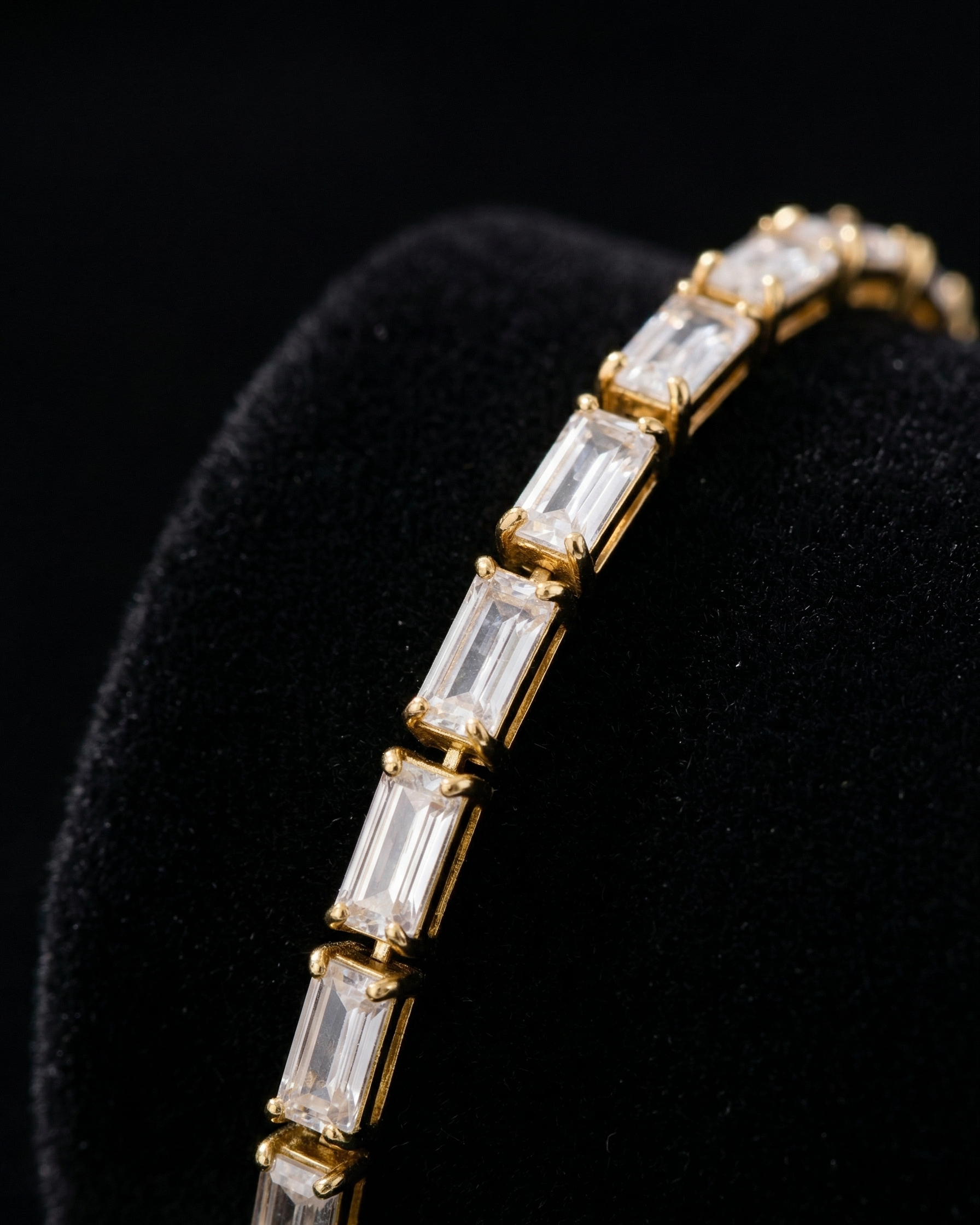 Gold bracelet with baguette-cut diamonds on a black background