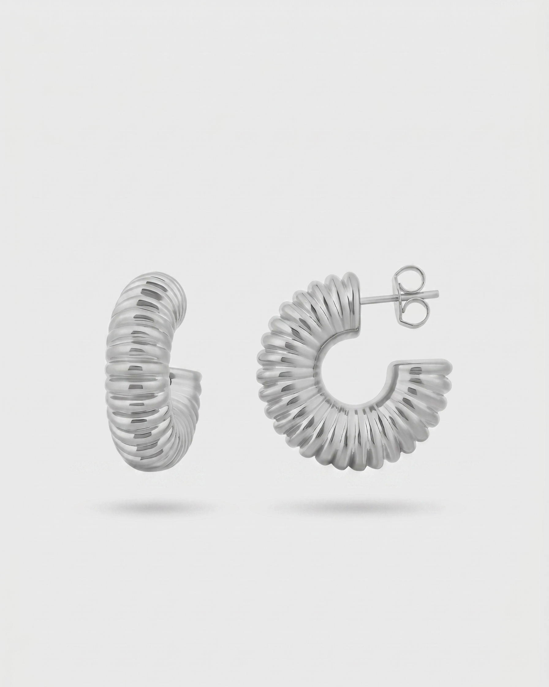Silver hoop earrings on a light gray background