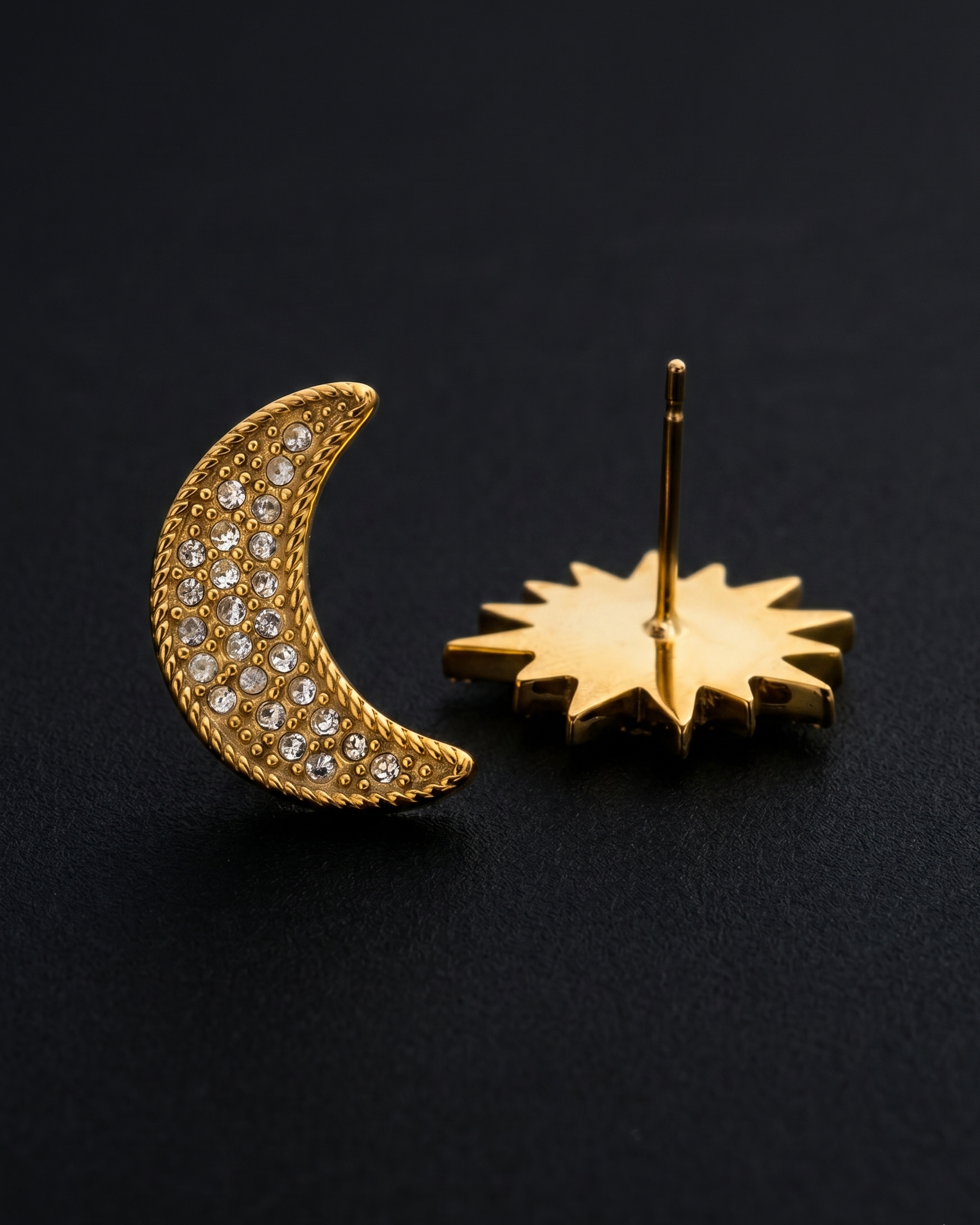 Gold moon and star earrings on a black background