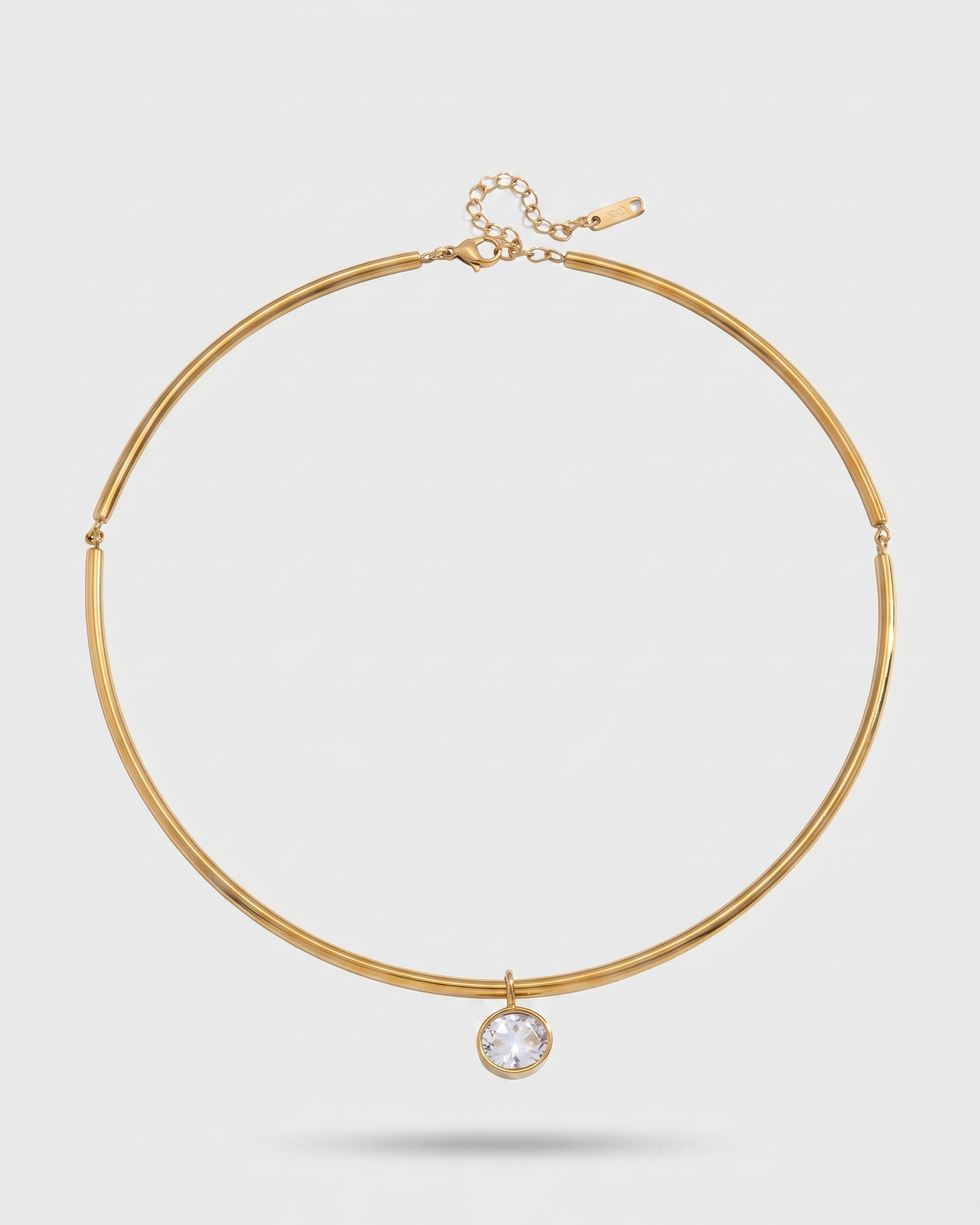 Gold necklace with a pendant on a light gray background