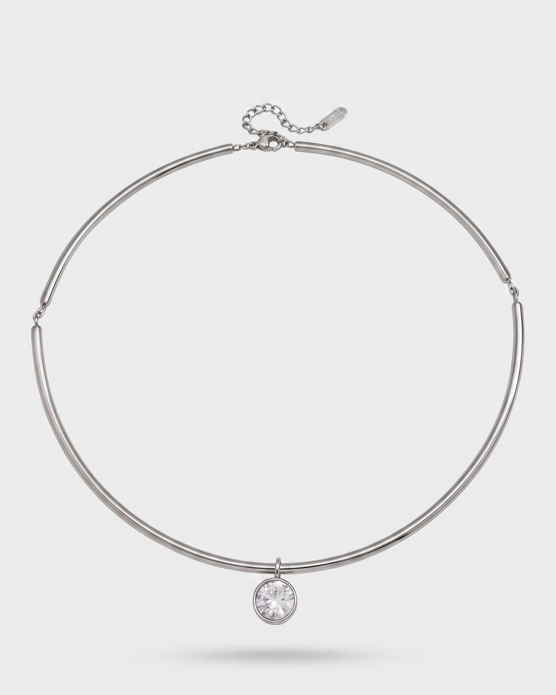 Silver necklace with a round pendant on a light gray background