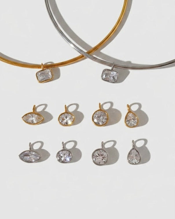 Two gold and silver bangles with matching earrings on a light gray background