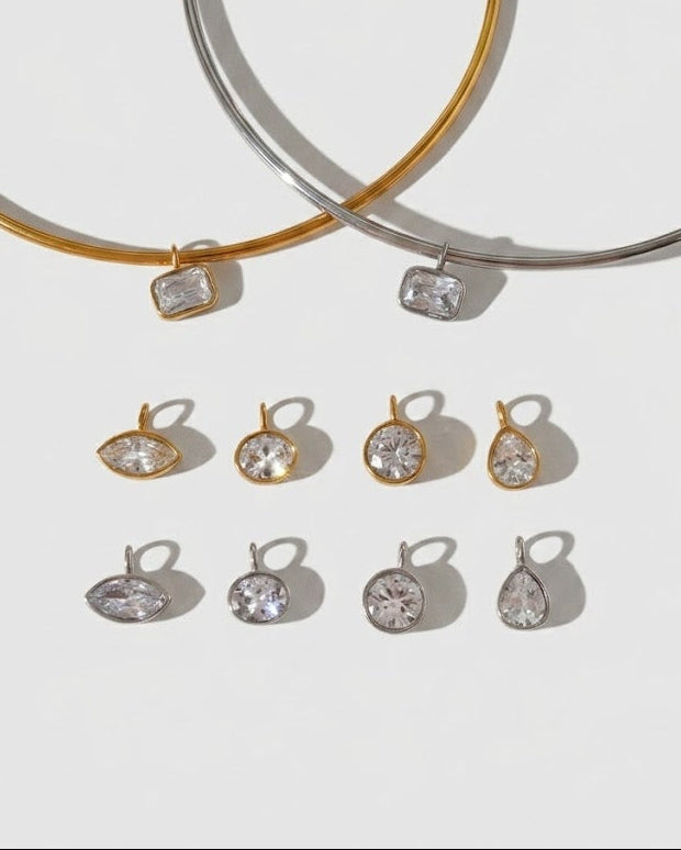 Two gold and silver bangles with matching earrings on a light gray background