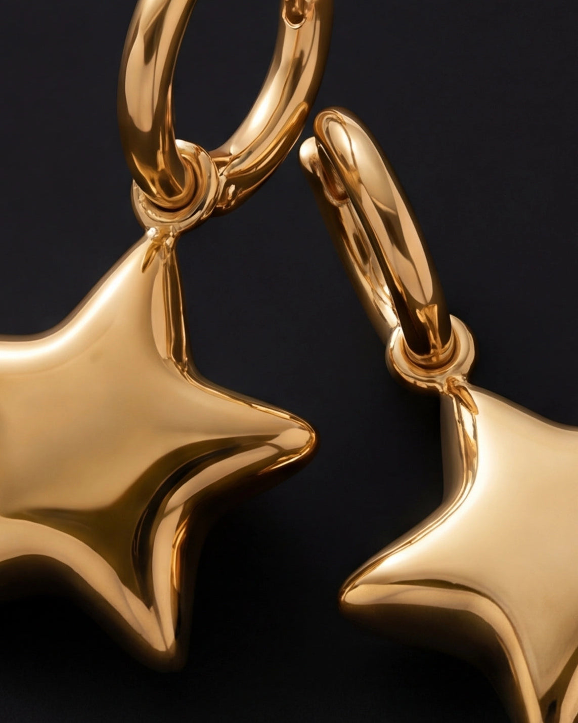 Gold star-shaped earrings on a black background