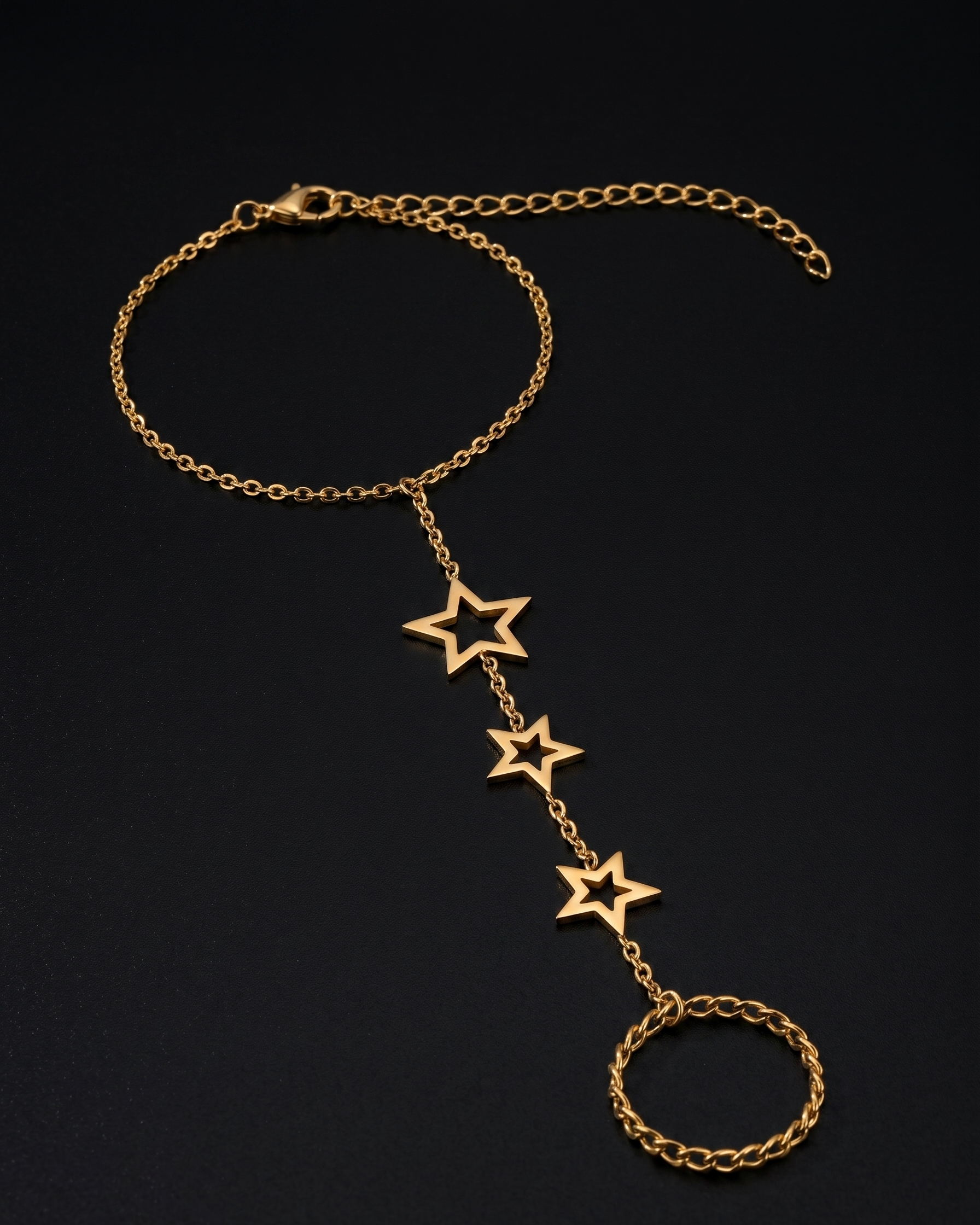 Gold chain bracelet with star-shaped charms on a black background