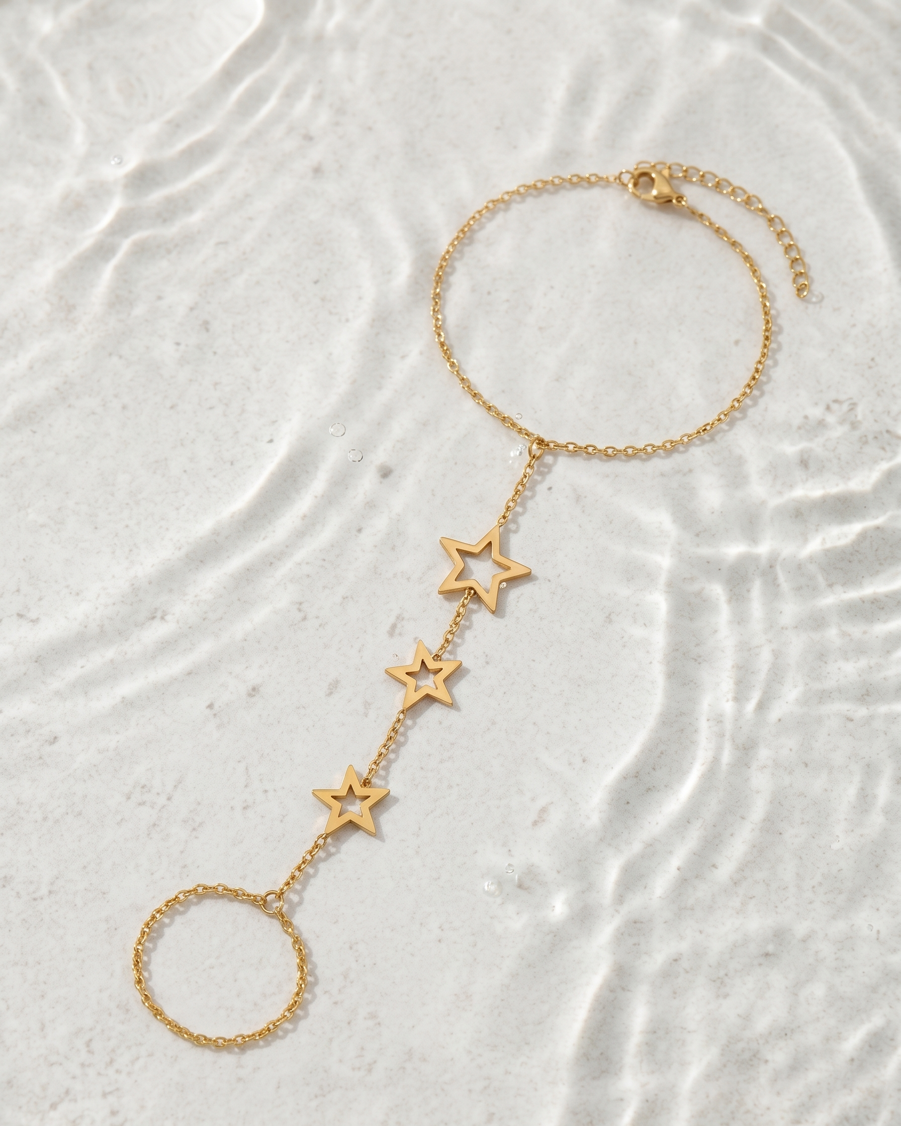 Gold star bracelet on a textured white surface