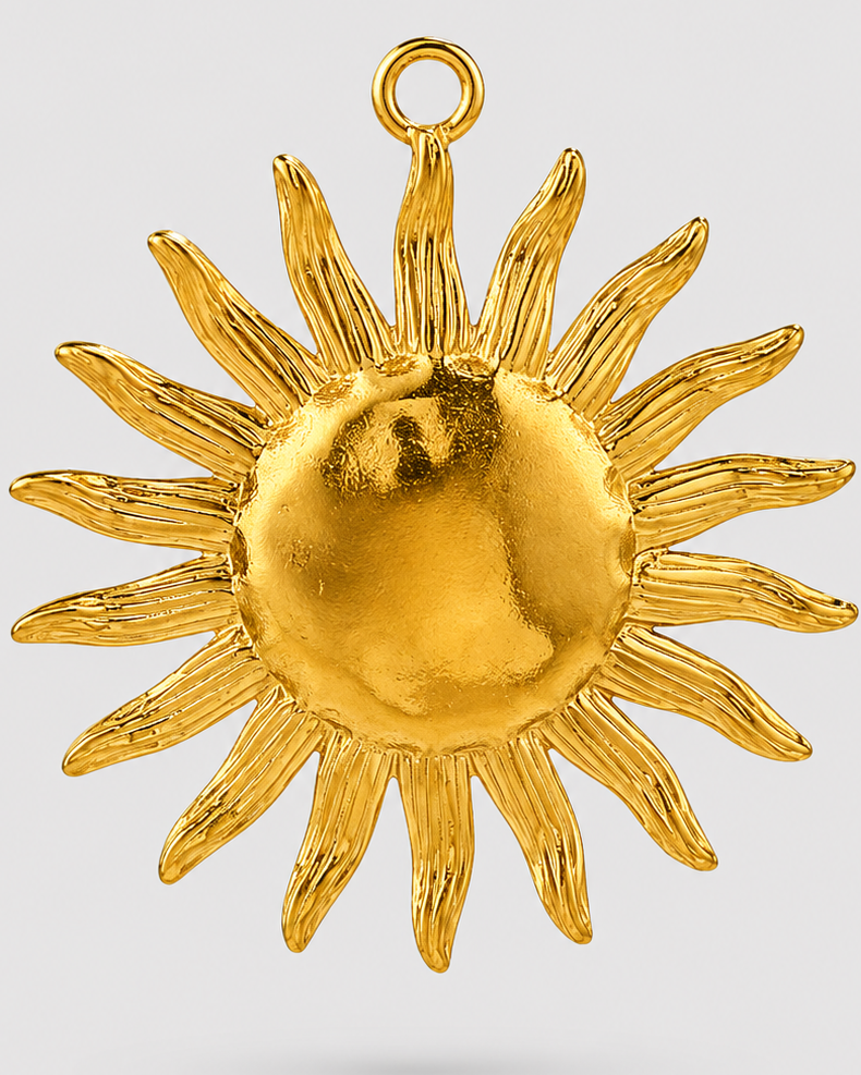 A gold sun pendant with textured rays and a polished center, suspended from a small top loop, shown against a light gray background.