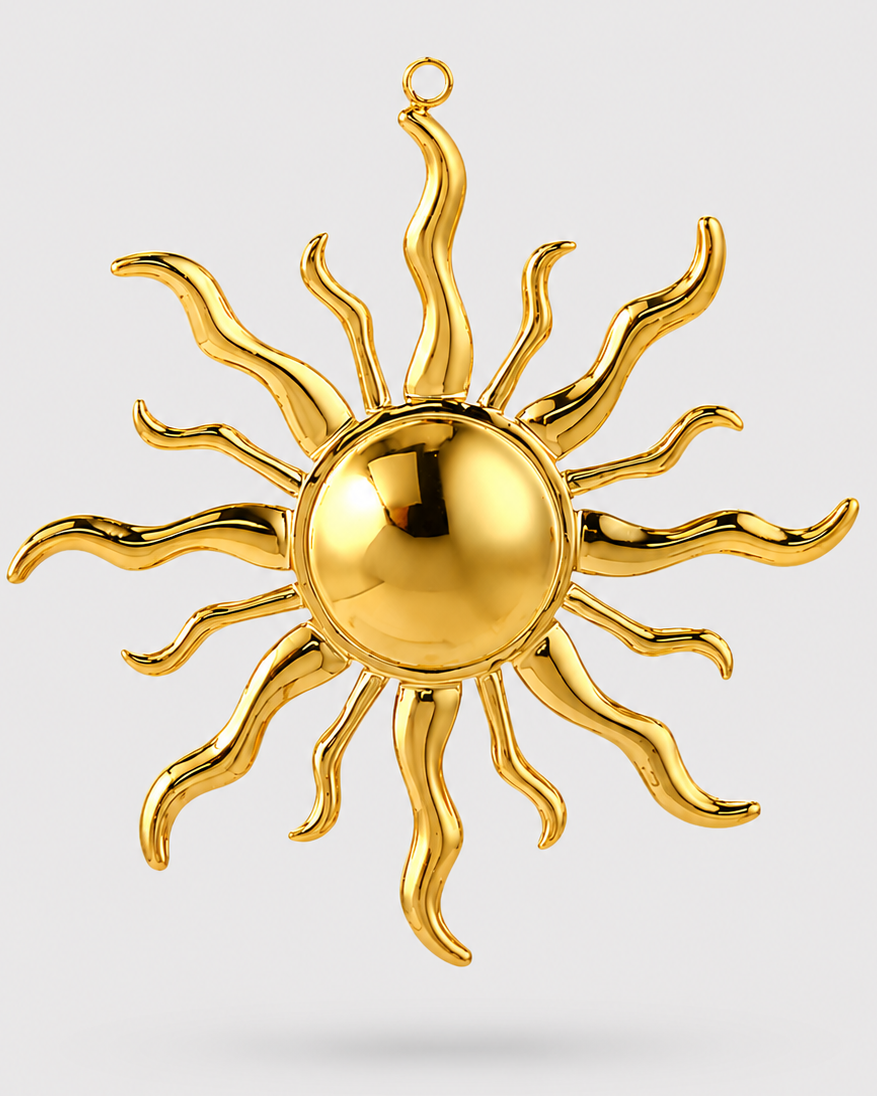 A polished gold sun pendant or charm with a spherical center and radiating wavy rays, shown against a light gray background.