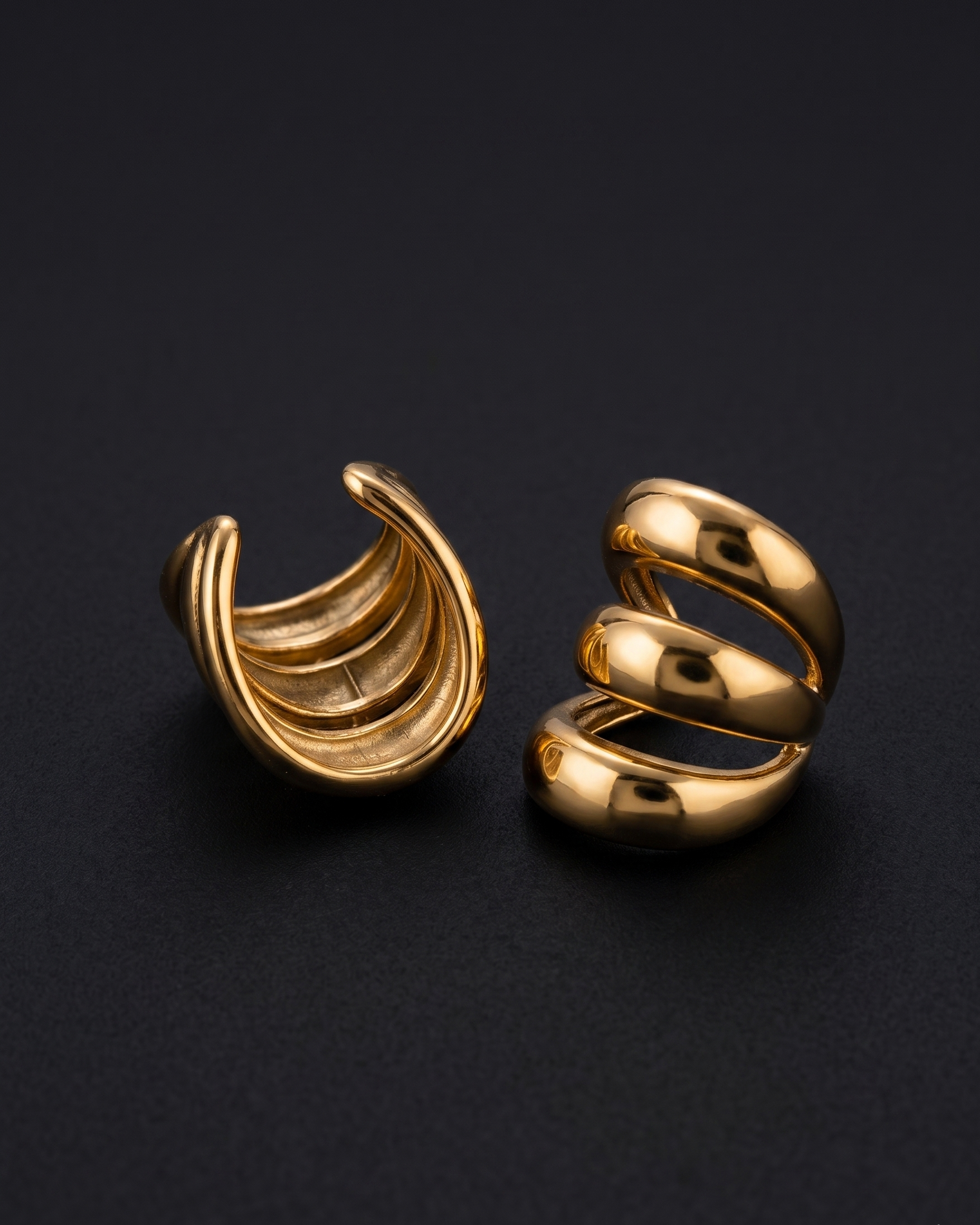 Pair of gold spiral earrings on a black background