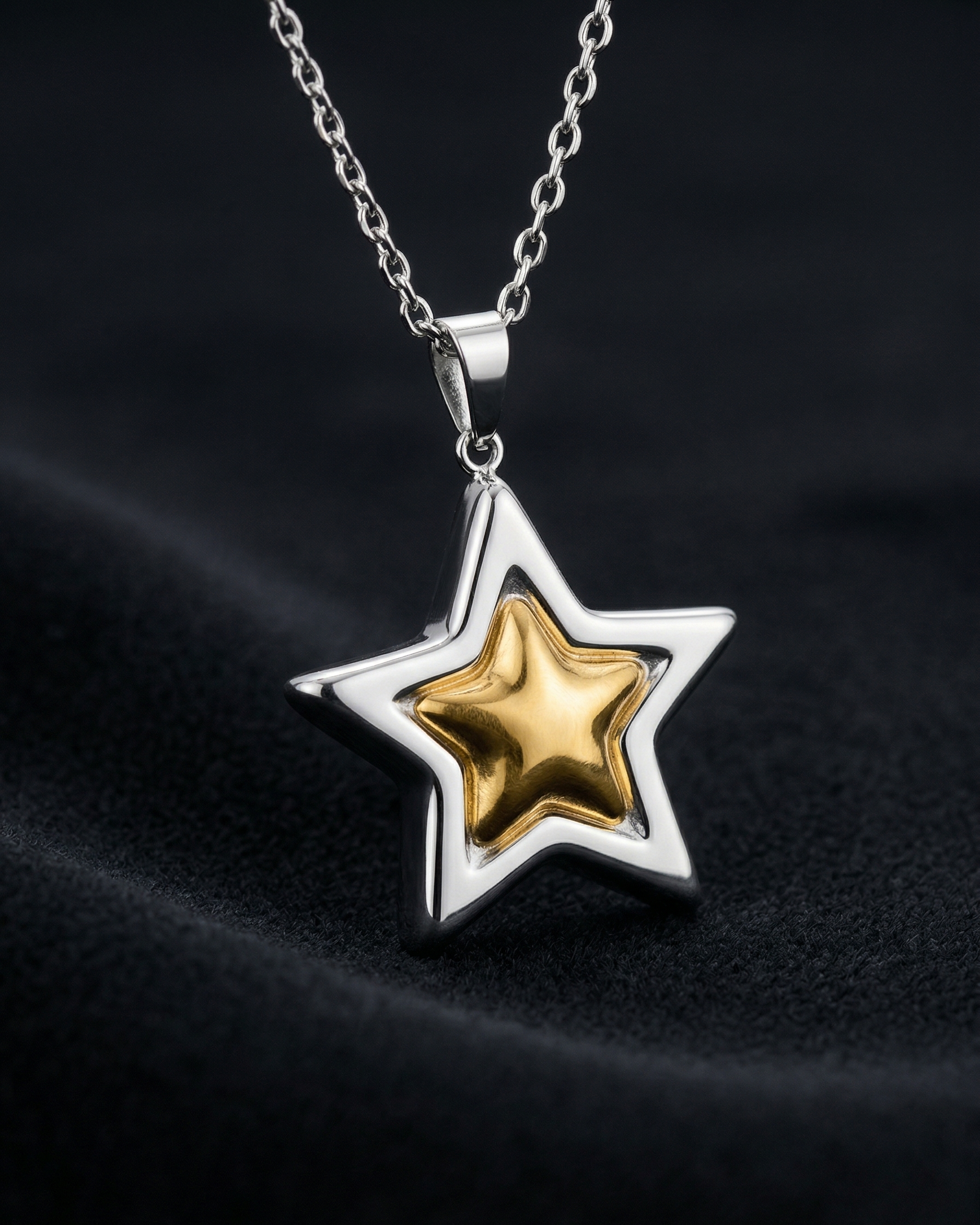 Star-shaped pendant with gold center and silver outline on a dark fabric background
