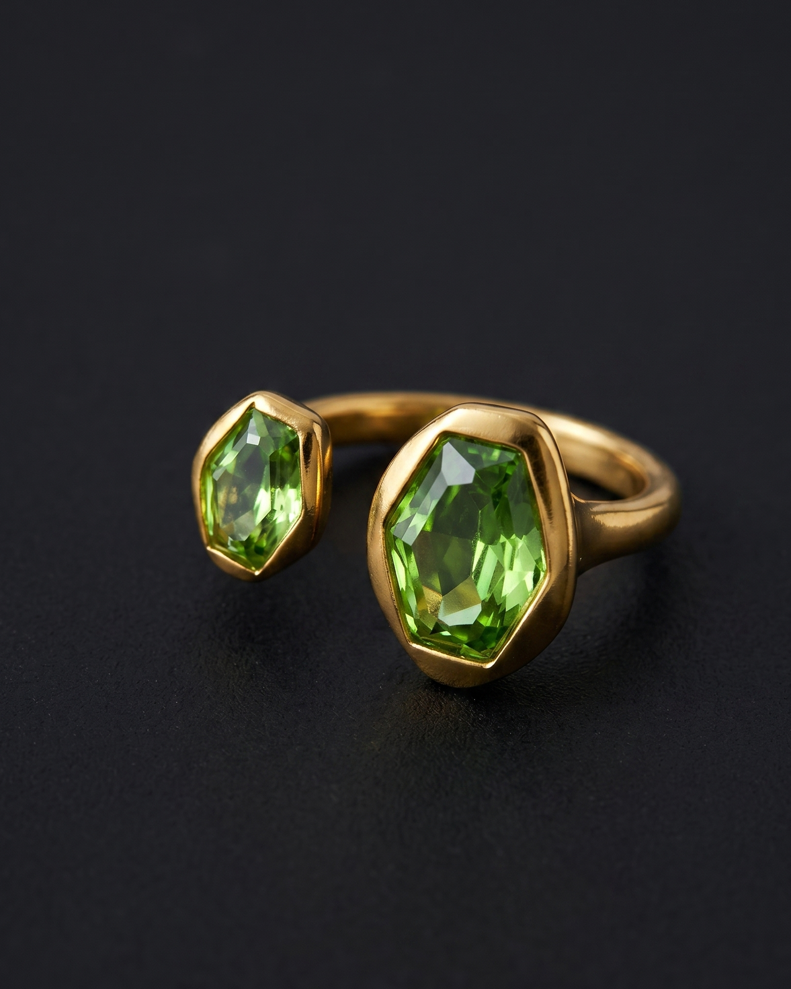 Gold ring with green gemstones on a black background