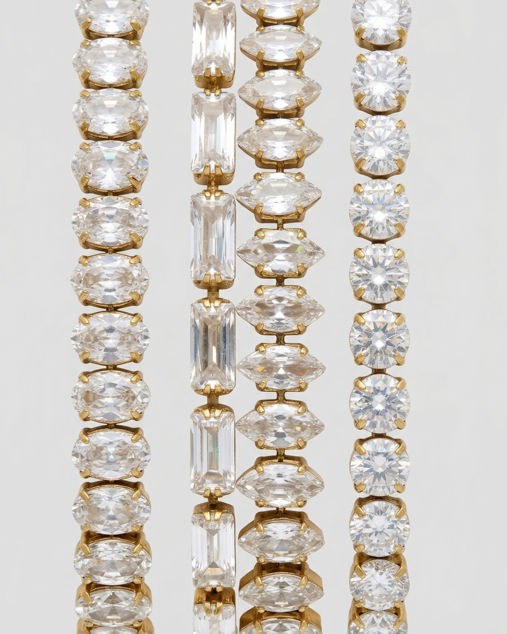 Three gold and diamond bracelets on a light gray background