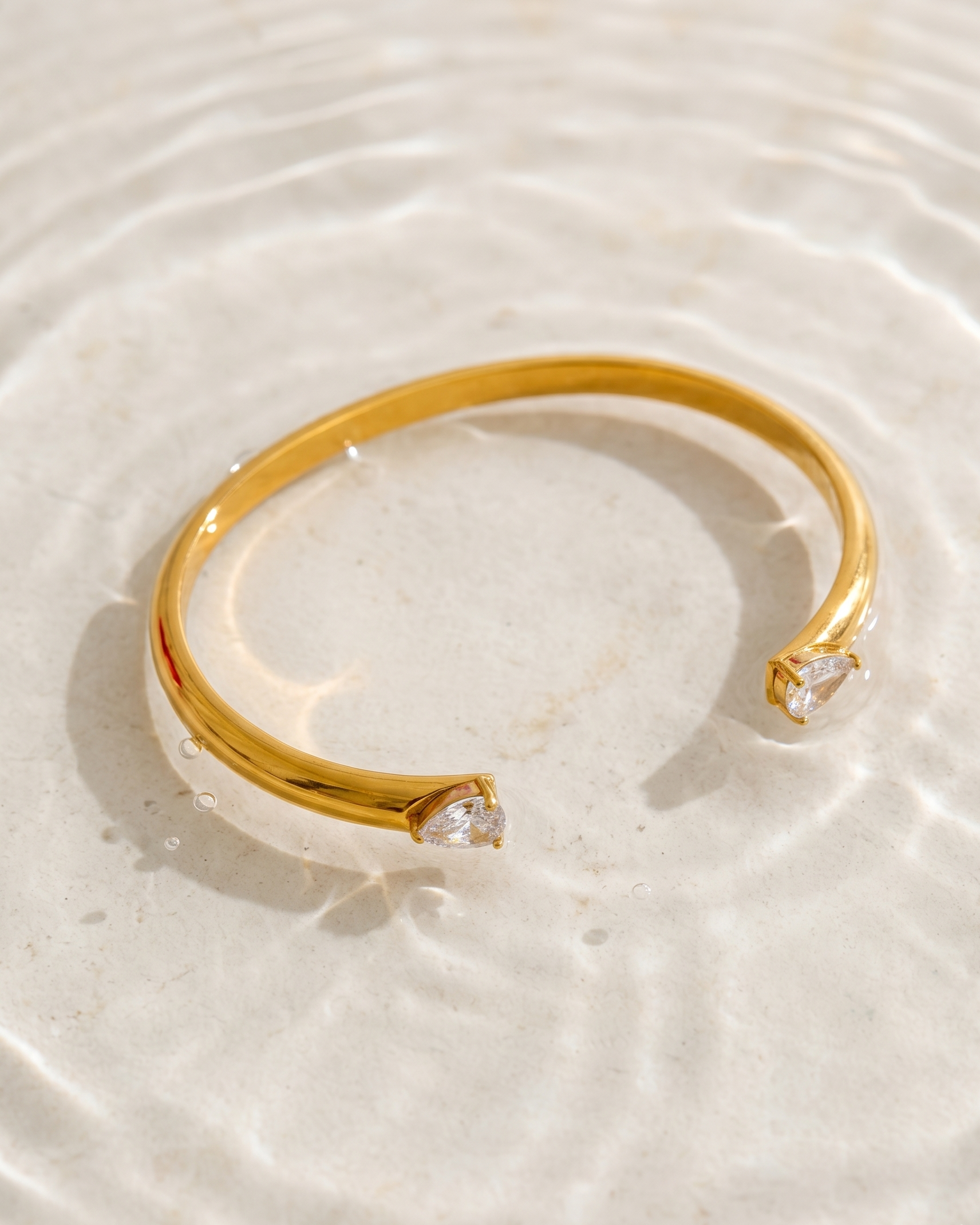 Gold bracelet with a diamond on a light background
