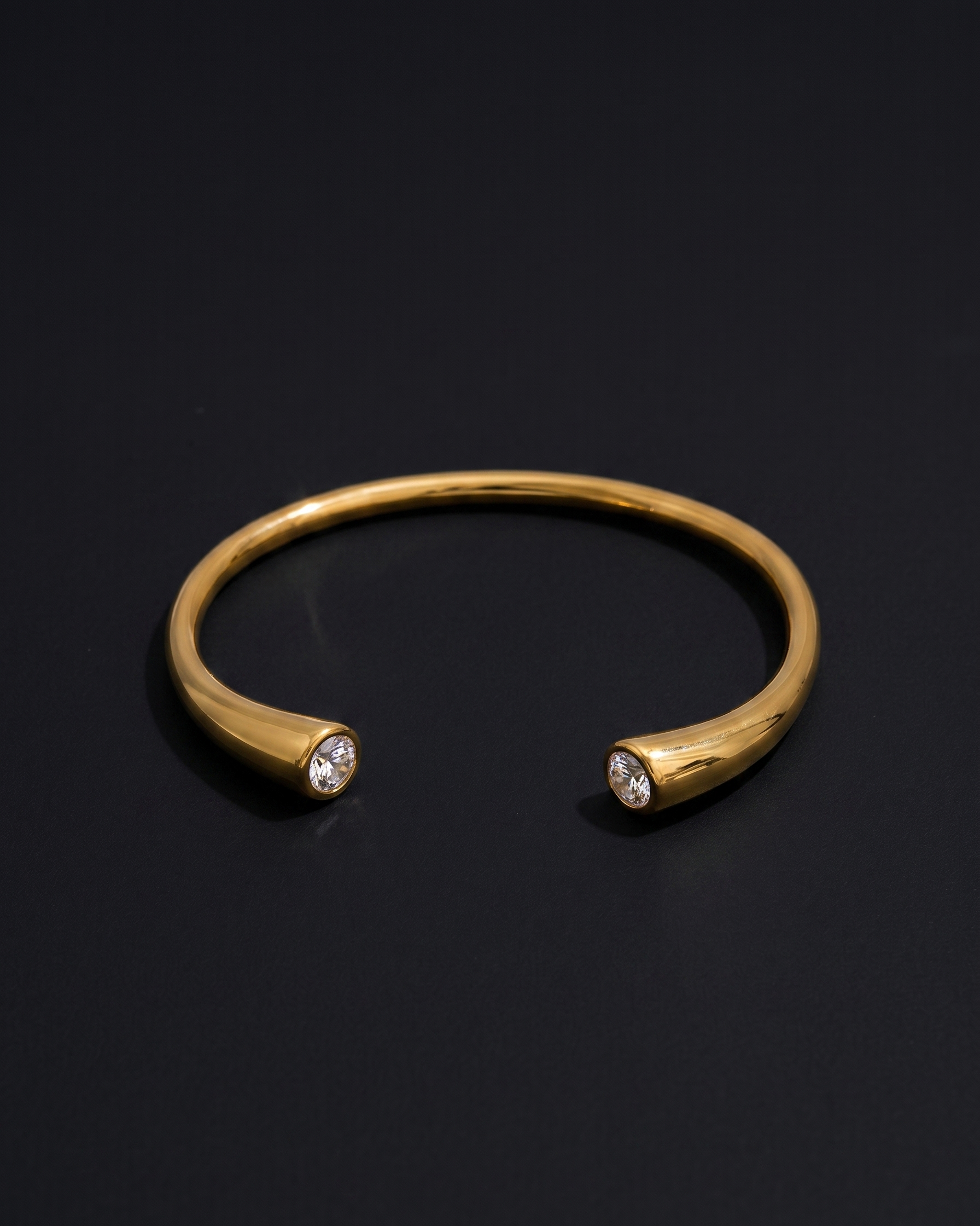 Gold bracelet with embedded stones on a black background