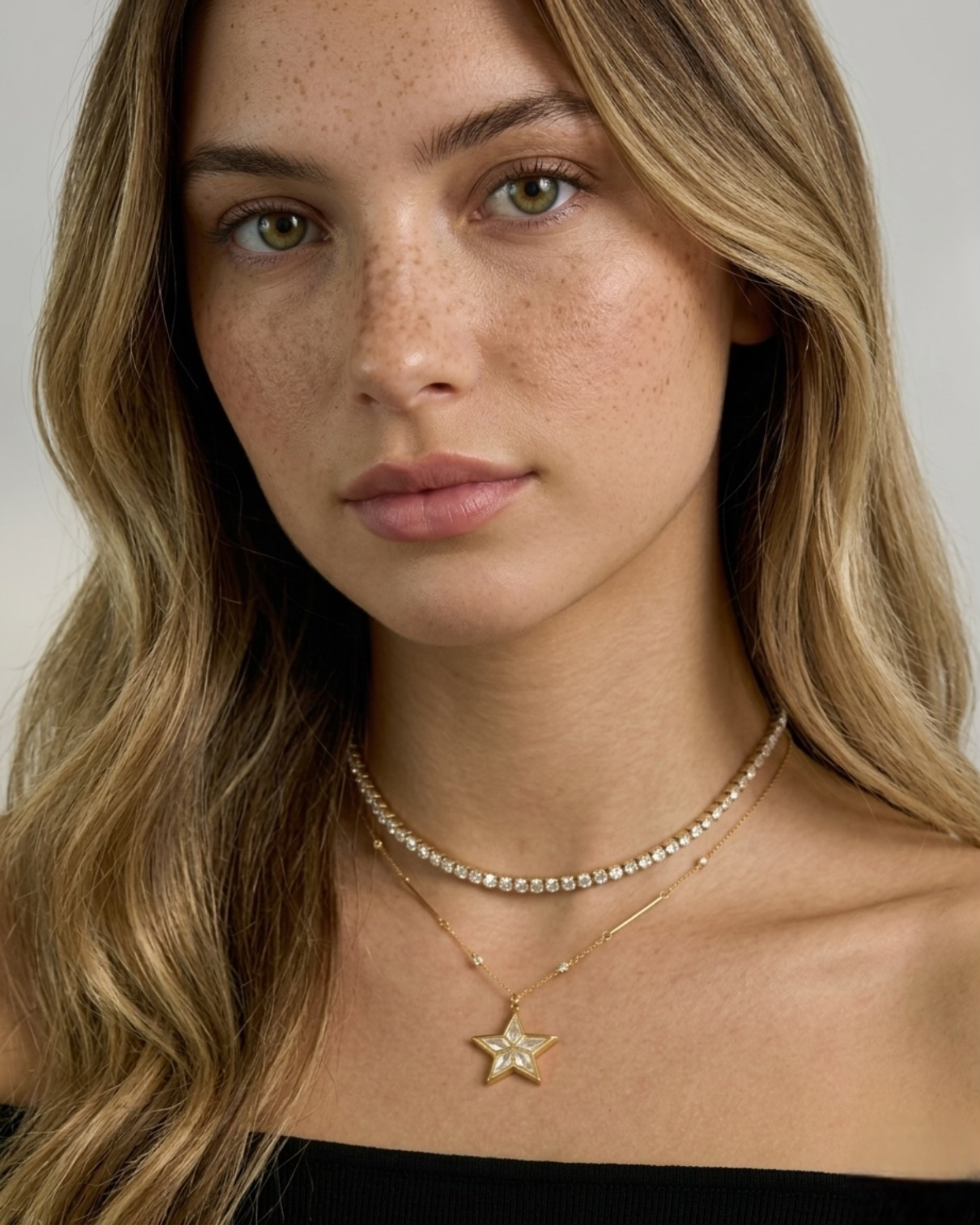 Woman wearing a star-shaped necklace with a plain background