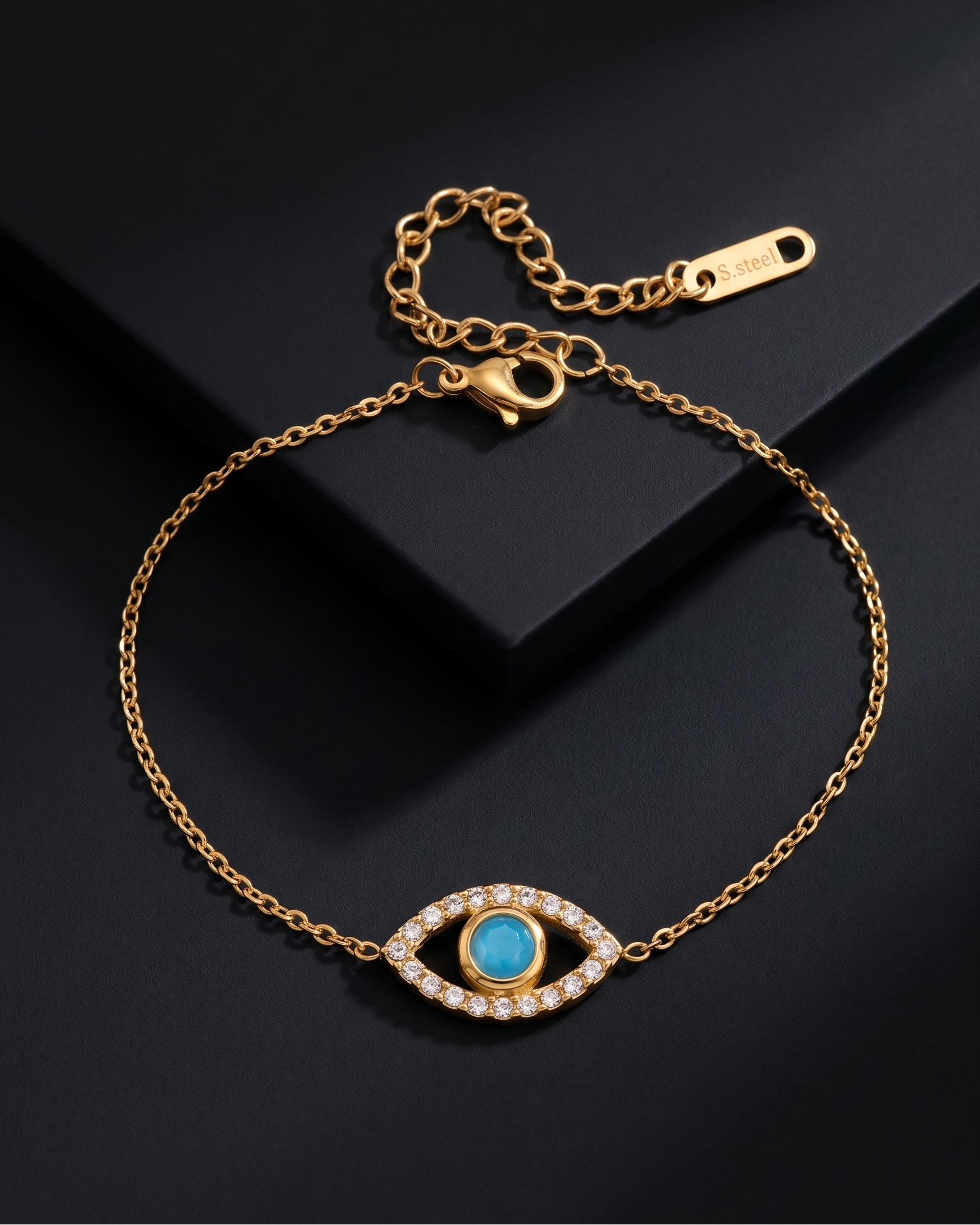 Gold bracelet with a turquoise eye charm on a black background