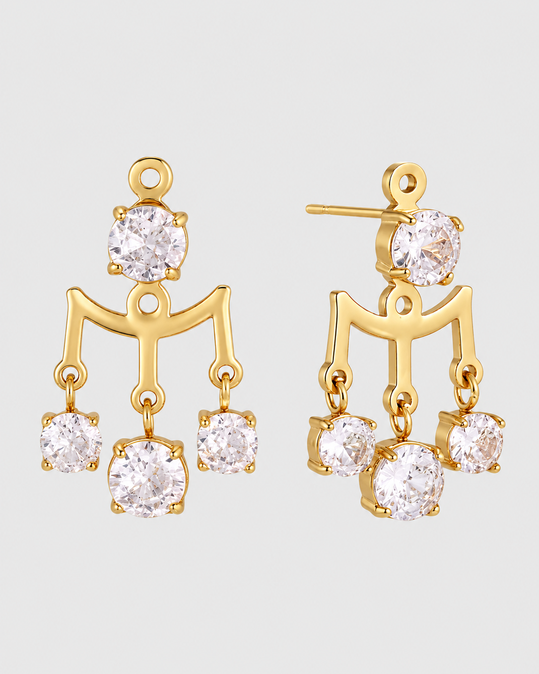 A pair of gold dangle earrings with clear round-cut gemstones, shown against a light gray background.